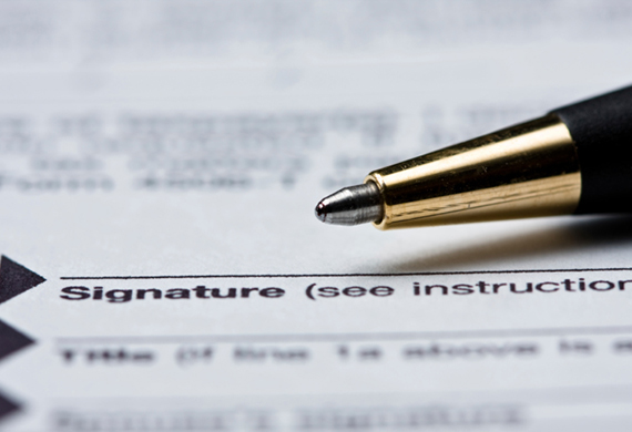 Signature line on a document with a pen