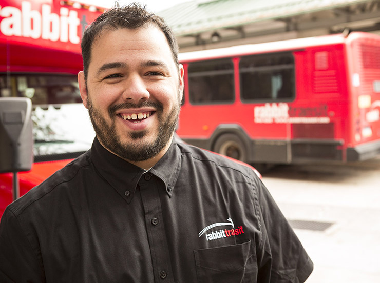 driver-smiles-in-front-of-buses