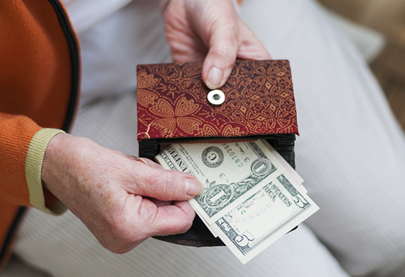 senior woman pulling cash from her purse