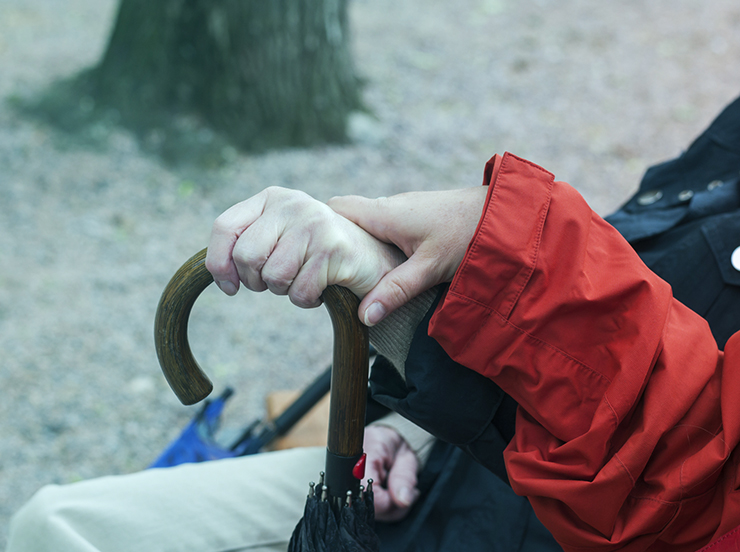 Hands of two women holding the handle of an umbrella