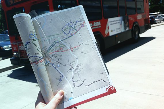 ride guide in a hand with a bus in the background