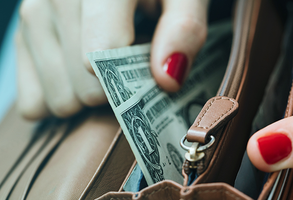 woman's hand taking money out a wallet