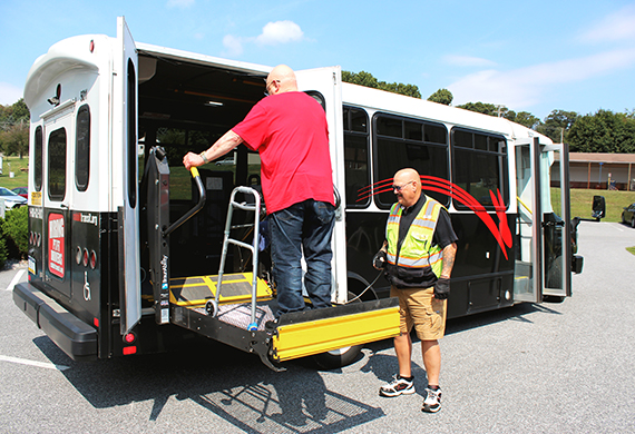 rider entering a paratransit vehicle with an assisted lift